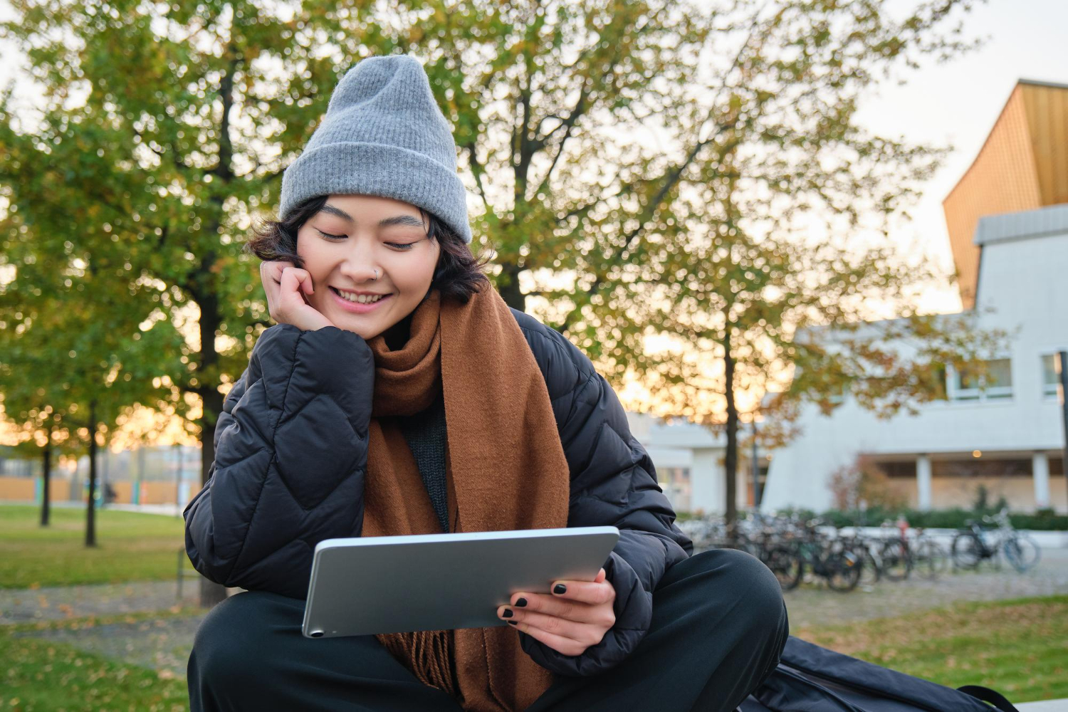 A girl is sitting on the street with a tablet